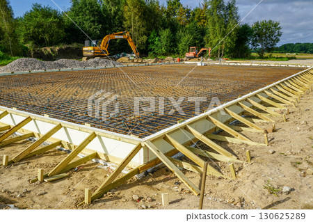 Reinforced steel rebar foundation with wooden formwork prepared for concrete slab construction Reinforced steel rebar foundation with wooden formwork prepared for concrete slab construction 130625289