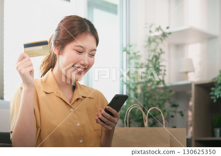 Online shopping. Excited woman celebrating her purchase with smartphone. Online shopping. Excited woman celebrating her purchase with smartphone. 130625350
