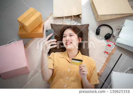 Online shopping. Smiling woman enjoying her shopping experience with a credit card. Online shopping. Smiling woman enjoying her shopping experience with a credit card. 130625358