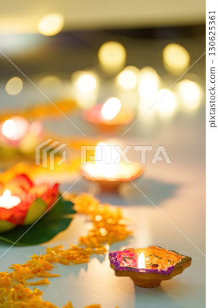 Diwali Decor. Elegant candles surrounded by marigold flowers for festive ambiance. 130625361