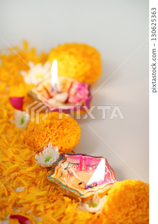 Diwali Festival. Colorful oil lamps glowing on marigold petals for celebration. 130625363