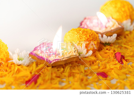 Diwali Festival. Lit oil lamps with marigold flowers and decorative petals. 130625381