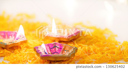 Diwali Festival. Vibrant oil lamps illuminating marigold petals. 130625402