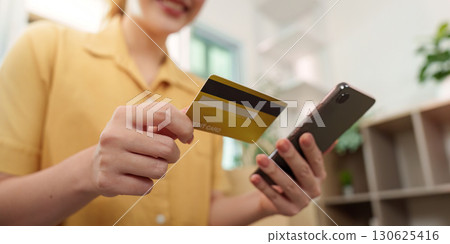 Cyber Monday shopping. Woman using smartphone and credit card for online purchases. Cyber Monday shopping. Woman using smartphone and credit card for online purchases. 130625416