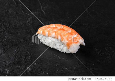 Delicious nigiri sushi with shrimp lying on dark stone background Delicious nigiri sushi with shrimp lying on dark stone background 130625978