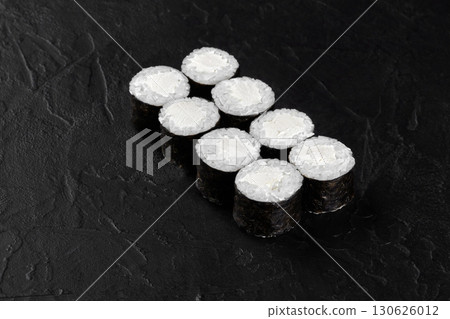Eight sushi rolls with cream cheese filling resting on black stone surface Eight sushi rolls with cream cheese filling resting on black stone surface 130626012