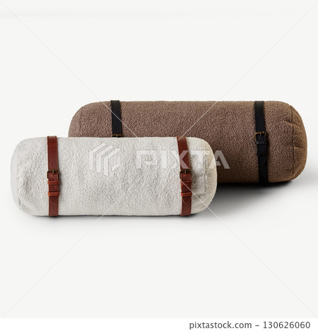 Two fluffy bolster pillows with leather straps resting on white surface Two fluffy bolster pillows with leather straps resting on white surface 130626060