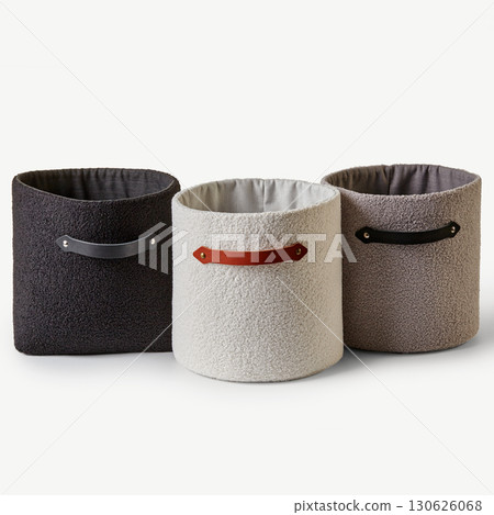 Three empty cylinder shaped baskets with leather handles standing on white background 130626068