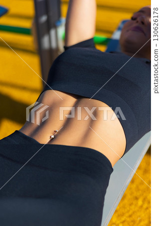 Fit woman performing outdoor workout on a sunny day Fit woman performing outdoor workout on a sunny day 130626178