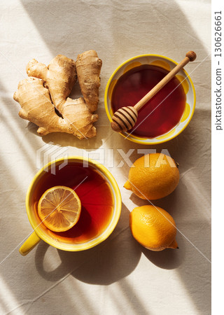 Flat Lay with Lemon Tea, Ginger and Honey on Light Table under Sun Light 130626661