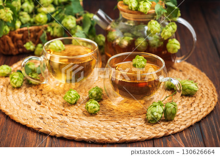 Hop Tea with Fresh Hops in Glass Cups and Teapot on Rustic Background 130626664