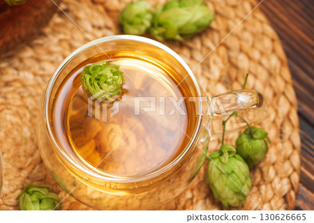 Hop Tea with Fresh Hops in Glass Cups and Teapot on Rustic Background 130626665