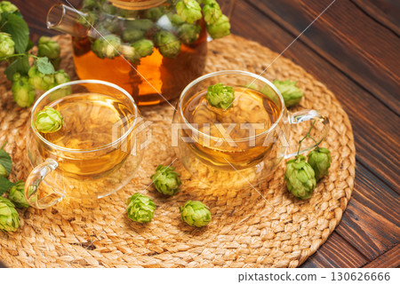 Hop Tea with Fresh Hops in Glass Cups and Teapot on Rustic Background 130626666