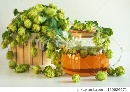 Hop Tea in Glass Teapot with Fresh Hops on Table Hop Tea in Glass Teapot with Fresh Hops on Table 130626671