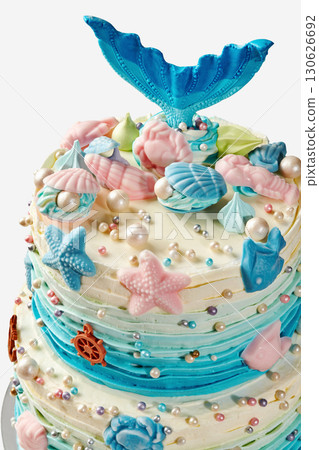Delicious mermaid birthday cake decorated with starfish, seashells, pearls, and a mermaid tail 130626692