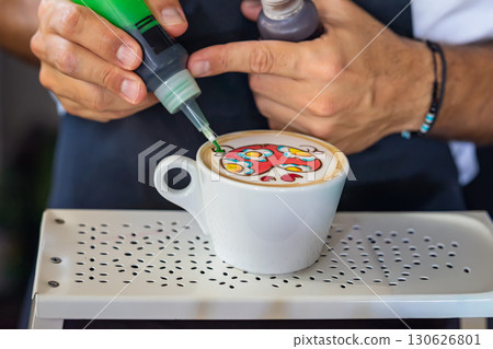 Barista creating colorful latte art with bright patterns on cappuccino foam using liquid food colors. Concept of creative coffee, barista skills, artistic drink preparation 130626801
