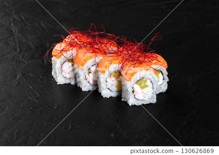 Philadelphia uramaki sushi rolls with salmon, shrimp, avocado, cream cheese and red spice on black background Philadelphia uramaki sushi rolls with salmon, shrimp, avocado, cream cheese and red spice on black background 130626869