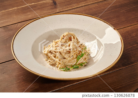 Creamy spaghetti carbonara with parmesan and herbs on rustic wooden table Creamy spaghetti carbonara with parmesan and herbs on rustic wooden table 130626878