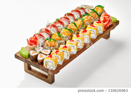 Sushi set beautifully displayed on wooden serving board with ginger and wasabi 130626963