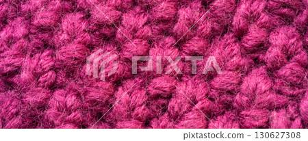 Knitted woolen fabric pattern in rich magenta. Macro texture of a cozy sweater, thick woven yarn Knitted woolen fabric pattern in rich magenta. Macro texture of a cozy sweater, thick woven yarn 130627308
