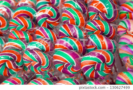 Color lollipop, spiral candy on stick, colorful striped lollypop, round fruit caramel, multicolored confectionery 130627499