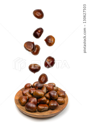 Falling edible sweet whole chestnuts, chest nuts in air isolated on white background 130627503