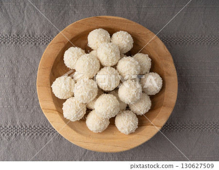 Coconut candies pile, coco ball. White truffle ball, indian ladoo or laddu with sweet cream and coco 130627509