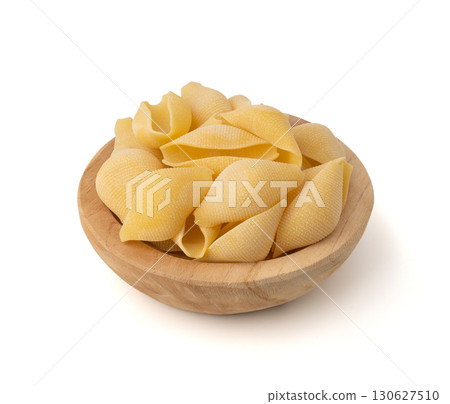Raw conchiglioni pasta isolated. Dry conchiglie noodle in shell shape, big Italian macaroni Raw conchiglioni pasta isolated. Dry conchiglie noodle in shell shape, big Italian macaroni 130627510