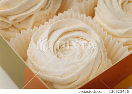 Delicate vanilla marshmallows in elegant packaging, soft swirl texture, close-up 130628436