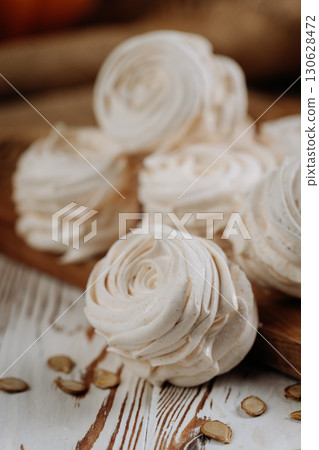 Homemade pumpkin marshmallows on rustic wooden table with seeds and autumn decor Homemade pumpkin marshmallows on rustic wooden table with seeds and autumn decor 130628472