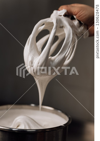 Whipped marshmallow cream pulled from mixer, close-up of airy texture and sweet dessert base 130628478