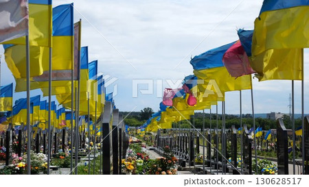 View on countless graves of ukrainian soldiers alley of glory in Kharkiv decorated with waving blue-yellow flags. The site commemorates soldiers who died during russian invasion in Ukraine. Slow mo View on countless graves of ukrainian soldiers alley of glory in Kharkiv decorated with waving blue-yellow flags. The site commemorates soldiers who died during russian invasion in Ukraine. Slow mo 130628517