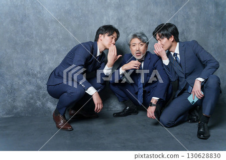 Businessmen having a secret conversation 130628830