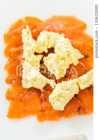 Generous dollops of wasabi cream cheese mixture placed over the smoked salmon, ready for spreading. Generous dollops of wasabi cream cheese mixture placed over the smoked salmon, ready for spreading. 130628880