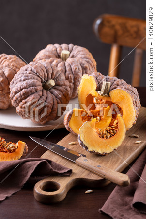 Black Futsu Squash With Wedges And Orange Flesh On Kitchen Table Black Futsu Squash With Wedges And Orange Flesh On Kitchen Table 130629029