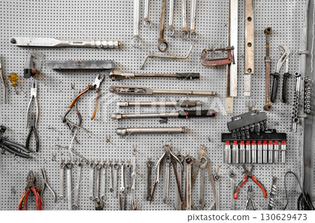 Various wrenches and hand tools hanging on 130629473
