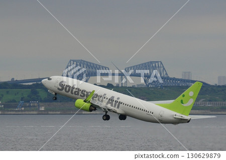 A passenger plane taking off with Tokyo Bay in the background, a Solaseed Air plane landing A passenger plane taking off with Tokyo Bay in the background, a Solaseed Air plane landing 130629879