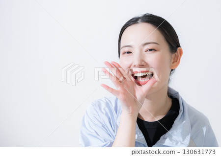 A woman in sportswear cheering, looking at the camera, close-up of her smile, "Go for it!" 130631773