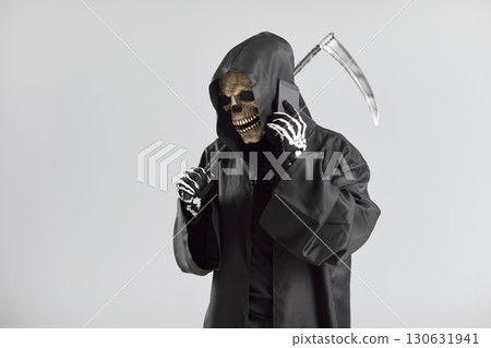Grim Reaper Talking on Phone with Scythe on Grey Background Grim Reaper Talking on Phone with Scythe on Grey Background 130631941