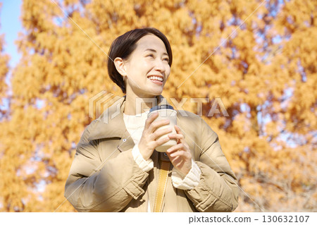 中年婦女在戶外喝咖啡，秋葉 130632107