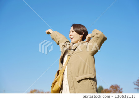 Woman, middle-aged, stretching, blue sky 130632115