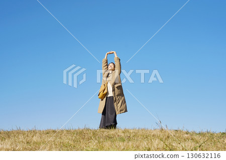 Woman, middle age, stretching, blue sky, whole body 130632116
