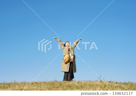 Woman, middle age, stretching, blue sky, whole body Woman, middle age, stretching, blue sky, whole body 130632117