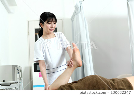 微笑的女性治療師正在治療一名男性患者 130632247