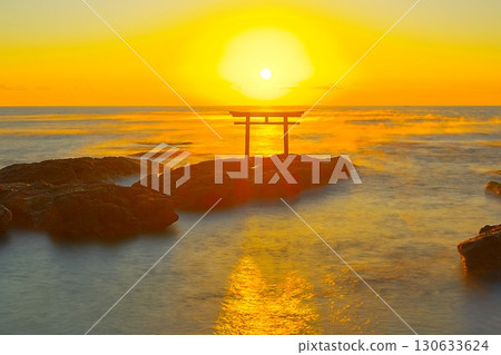 Scenery of the sacred torii gate of Oarai Isosaki Shrine and the morning sun rising over the calm ocean Ver.3 130633624