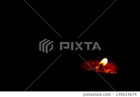 Burning Clay Oil Lamp in Darkness Symbolizing Light and Hope 130633674