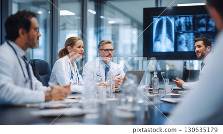 Doctors reviewing radiography in conference room at hospital. 130635179