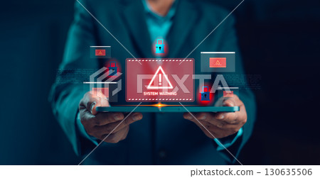 Businessman holding tablet with system warning alert on virtual screen, concept of cybersecurity risk, data breach, malware attack, online fraud, computer failure, digital protection and IT security. 130635506
