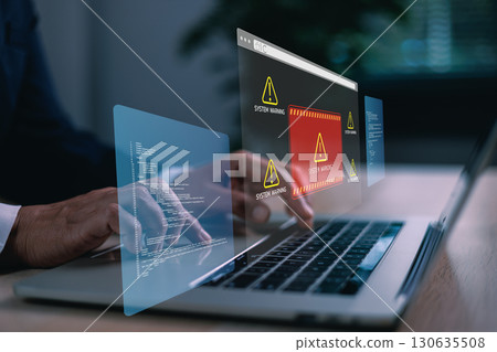 Hands typing on laptop with digital system warning alert on virtual screen, concept of cybersecurity threat, data breach, malware, coding error, online risk, computer failure and IT protection. Hands typing on laptop with digital system warning alert on virtual screen, concept of cybersecurity threat, data breach, malware, coding error, online risk, computer failure and IT protection. 130635508