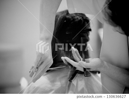 A woman cutting her hair in a hair salon 130636627
